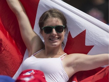 A fan waves a Canadian flag as the crowd celebrates Canada Day during interleague baseball action between the Toronto Blue Jays and Milwaukee Brewers in Toronto on Tuesday July 1 , 2014.