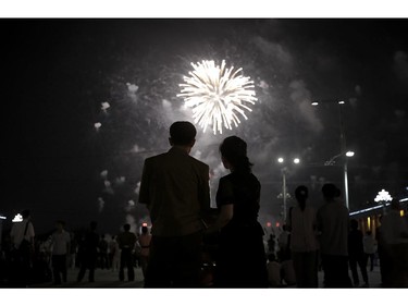 A North Korean couple is silhouetted against a fireworks explosion, Sunday, July 27, 2014 in central Pyongyang, North Korea. North Koreans gathered at Kim Il Sung Square to watch a fireworks display as part of celebrations for the 61st anniversary of the armistice that ended the Korean War.(AP Photo/Wong Maye-E)