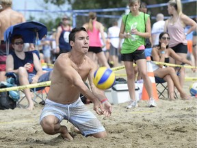 A player digs the ball as he takes part in the HOPE Volleyball Summerfest at Mooney's Bay Beach on Saturday, July 12, 2014.
