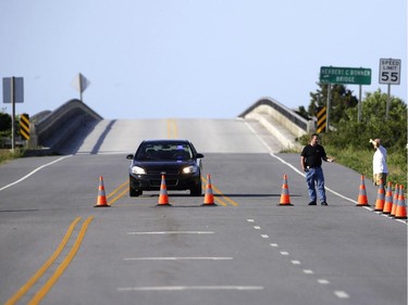 A police checkpoint prevents traffic from crossing the Bonner Bridge on Highway 12 while safety inspections continue following Hurricane Arthur's impact on the Outer Banks near Nags Head, N.C., Saturday, July 5, 2014. Businesses on two of North Carolina's barrier islands hoped to salvage the rest of the holiday weekend after Arthur clipped the state without causing major damage before churning north toward Canada and losing strength early Saturday morning.