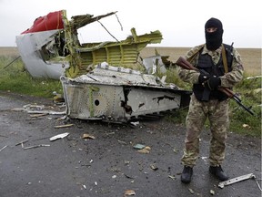 A Pro-Russian fighter stands guard at the site of a crashed Malaysia Airlines passenger plane near the village of Hrabove, Ukraine, eastern Ukraine Friday, July 18, 2014. Rescue workers, policemen and even off-duty coal miners were combing a sprawling area in eastern Ukraine near the Russian border where the Malaysian plane ended up in burning pieces Thursday, killing all 298 aboard.