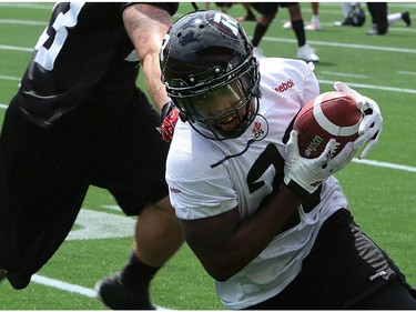 A receiver runs the ball as the Ottawa Redblacks practice at TD Place Stadium at Lansdowne Park on Monday, July 14, 2014.