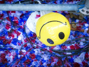 A smily face beach ball sits under the Bell stage in a mess of wet confetti on closing night of Bluesfest, Sunday July 13, 2014.