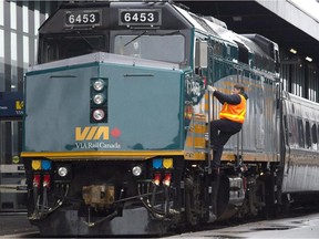A Via Rail employee climbs aboard a locomotive at the train station in Ottawa on Monday, December 3, 2012. RCMP say two suspects arrested in an alleged terror attack against a Via Rail passenger train had "direction and guidance" from al-Qaida elements in Iran.