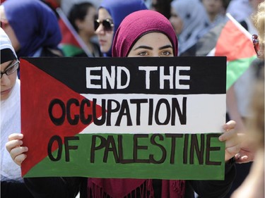 A woman protests in front of the Langevin Block in support of Palestinians in Gaza in Ottawa on Tuesday, July 22, 2014.