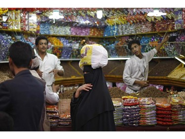 A Yemeni woman, center, shops in preparation for the upcoming Eid al-Fitr festival, at a market in the old city of Sanaa, Yemen, Sunday, July 27, 2014.