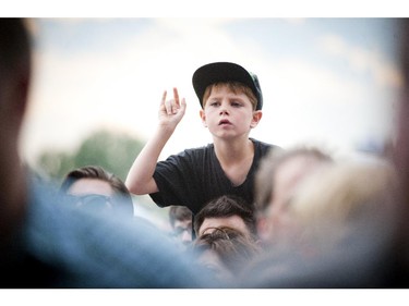 A young boy rocks out on someones shoulders during Violent Femmes performance on the Claridge Homes stage Sunday July 6, 2014 at Bluesfest held at LeBreton Flats.