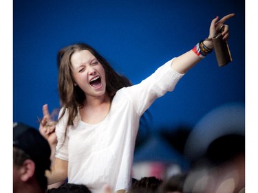 A young woman perched on shoulders of another fan gets excited for Lady Antebellum before they came on the Bell Stage Sunday July 6, 2014 at Bluesfest held at LeBreton Flats.