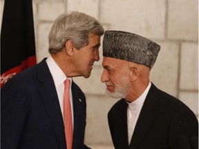 Afghanistan's president Hamid Karzai (R) and U.S. Secretary of State John Kerry (L) speak during a press conference at the Presidential Palace in Kabul, July 13, 2014. US Secretary of State John Kerry on July 12 held a second day of talks with Afghanistan's feuding presidential hopefuls, seeking a deal to "clean up the tally" after disputed elections.
