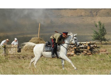 An actor dressed as a Russian soldier rides a horse, as others play the role  of  civilians during the re-enactment of the 1914 Battle of Tannenberg in Szkotowo, Poland, Sunday, July 27, 2014, marking the 100th anniversary of the beginning of World War I. History enthusiasts from across Europe gathered  to reconstruct the Battle of Tannenberg, an engagement between the Russian and German Empires in the first days of World War I.