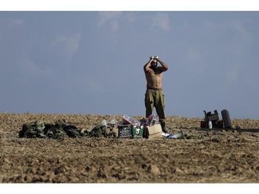 An Israeli soldier washes himself near the Israel and Gaza border, Sunday, July 27, 2014. Hamas on Sunday agreed to observe a 24-hour truce in Gaza after initially rejecting a similar Israeli offer, as fighting resumed and the two sides wrangled over the terms of a lull that international diplomats had hoped could be expanded into a more sustainable truce. Hamas spokesman Sami Abu Zuhri said the truce would go into effect at 2 p.m. (1100 GMT) Sunday. But shortly after the truce was to have started warning sirens wailed in southern Israel and the military said three rockets landed in the area, without causing casualties or damage.