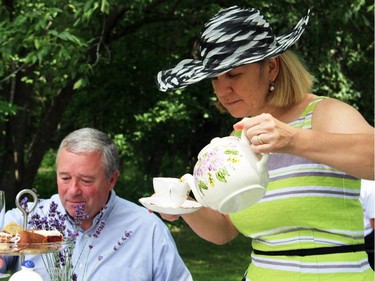 Andrea Keele pours tea for everyone at her table during the High Tea for Ryan's Well Foundation charity event, held Sunday, July 20, 2014, at a private home in Plaisance, Quebec.