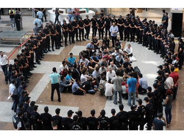 Anti-terror and riot police surround former colleagues detained on suspicion of spying or of illegally wiretapping government officials, including prime minister Recep Tayyip Erdogan and Turkey�s spy chief, inside a courhouse in Istanbul, Turkey Saturday, July 26, 2014. Turkey's state-run news agency says an Istanbul court has charged 20 police officers with illegal wiretapping and ordered their arrest pending a trial. The Anadolu Agency said 49 other officers are still waiting late Saturday to be questioned and face possible charges.(AP Photo)