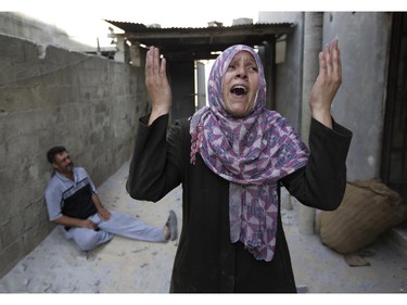 As her brother-in-law Mazen Keferna, background left, weeps, Palestinian Manal Keferna, 30, right, cries upon her return to the family house, destroyed by Israeli strikes in Beit Hanoun, northern Gaza Strip, Saturday, July 26, 2014. Thousands of Gaza residents who had fled Israel-Hamas fighting streamed back to devastated border areas during a lull Saturday, and were met by large-scale destruction: scores of homes were pulverized, wreckage blocked roads and power cables dangled in the streets.