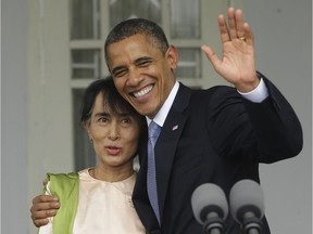 In this Nov. 19, 2012 file photo, U.S. President Barack Obama, right, waves as he embraces Myanmar democracy activist Aung San Suu Kyi after addressing members of the media at Suu Kyi's residence in Yangon, Myanmar.