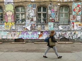 A woman walks past graffiti and street art in Revaler Strasse in Friedrichshain district on June 26, 2014 in Berlin, Germany.