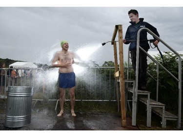 DUNGANNON, NORTHERN IRELAND - JULY 27:  An entrant is hosed down after takes part in the Irish Bog Snorkelling championship this afternoon at Peatlands Park on July 27, 2014 in Dungannon, Northern Ireland. The annual event sees male and female competitors swim the 60m length of the bog watched by scores of spectators and takes place on International Bog Day.