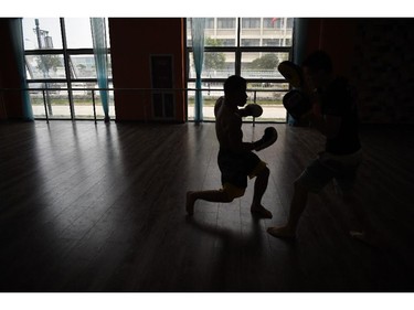 Two fighters train before the Kunlun Fight tournament in Zhoukou, in China's Henan province on July 27, 2014. The televised event featured kickboxing and mixed martial arts. Mixed martial arts fighting is growing in popularity in China, with events held across the country.