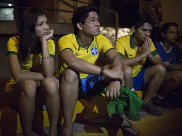 Brazil soccer fans sit outside the Sao Carlos hospital where Brazil's soccer player Neymar was taken after being injured during the World Cup quarterfinal soccer match between Brazil and Colombia, in Fortaleza, Brazil, Friday, July 4, 2014. Brazil's team doctor says Neymar will miss the rest of the World Cup after breaking a vertebrae during the team's 2-1 win.