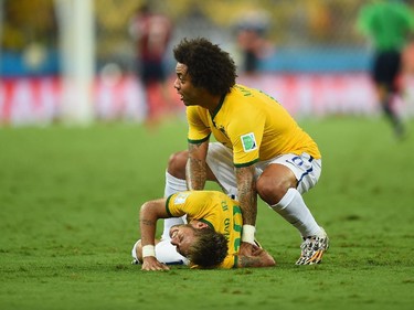 FORTALEZA, BRAZIL - JULY 04:  Neymar of Brazil lies on the field after a challenge as teammate Marcelo reacts during the 2014 FIFA World Cup Brazil Quarter Final match between Brazil and Colombia at Castelao on July 4, 2014 in Fortaleza, Brazil.