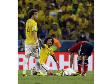 Brazil's Marcelo calls to the referee with David Luiz (4) as Neymar lies on the ground after being injured during the World Cup quarterfinal soccer match between Brazil and Colombia at the Arena Castelao in Fortaleza, Brazil, Friday, July 4, 2014. Brazil defeated Colombia 2-1 to advance to the semifinals.