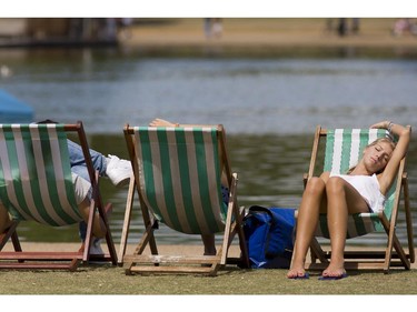 A woman rest on a deckchair by the Serpentine lake in Hyde Park, central London as England basks in warm weather on July 27, 2014.