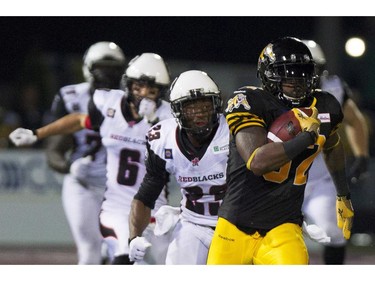 Hamilton Tiger-Cats running back C.J. Gable, right, is pursued by several Ottawa RedBlacks during an 83-yard reception that would lead to the game-winning touchdown late in the fourth quarter in their CFL home opener in Hamilton, Ont., Saturday, July 26, 2014.