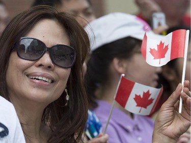A member of the crowd waves a Canadian flag during the annual Canada Day parade in Montreal, Tuesday, July 1, 2014.