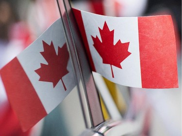 A Canadian flag is reflected in a car window during the annual Canada Day parade in Montreal, Tuesday, July 1, 2014.