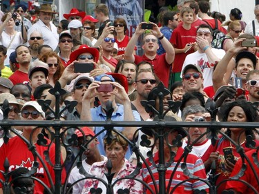 Crowds of people peer over gates of Parliament Hill to get photos and a look at dignitaries and Canada Day celebrations on Parliament Hill in Ottawa, Tuesday July 1, 2014.