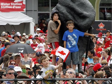 Crowds of people look over the gates of Parliament Hill to get a glimpse of Canada Day celebrations on Parliament Hill in Ottawa, Tuesday July 1, 2014.