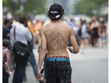 A man with a Canada Day message on his back looks on during the annual Canada Day parade in Montreal, Tuesday, July 1, 2014.