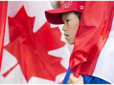 A young boy holds a Canadian flag as he participates in the annual Canada Day parade in Montreal, Tuesday, July 1, 2014.