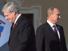 Canadian Prime Minister Stephen Harper walks past Russian President Vladimir Putin at the G20 Summit Thursday Sept.5, 2013 in St.Petersburg, Russia.