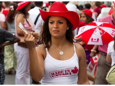 Chantal Cardenas tries to fan herself to escape the heat as people flock to Parliament Hill and the downtown core to enjoy Canada's 147th birthday. Photo taken at 11:52 on July 1, 2014.