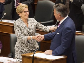 Ontario Finance Minister Charles Sousa is congratulated by Premier Kathleen Wynne after delivering the 2014 budget at Queen's Park in Toronto on Monday, July 14, 2014.