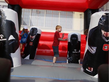 Children played in a Redblacks and 67's bouncy castle before the Redblacks' home opener against the Toronto Argonauts at TD Place on Friday, July 18, 2014.