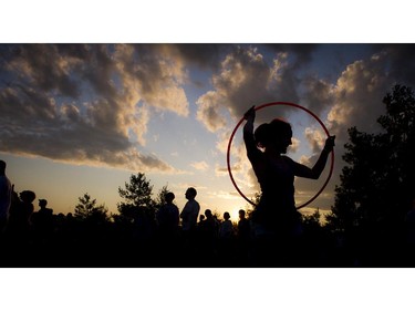 Christa Dakin hula hoops as the sun set over the River Stage Sunday July 13, 2014 on closing night of Bluesfest.