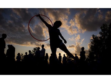 Christa Dakin hula hoops as the sun set over the River Stage Sunday July 13, 2014 on closing night of Bluesfest.