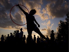 Christa Dakin hula hoops as the sun set over the River Stage Sunday July 13, 2014 on closing night of Bluesfest.