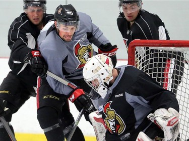 Cody Ceci, centre, angles to get the puck in the net at the Senators development camp, which had their final 3 on 3 tournament Monday July 7, 2014 at the Bell Sensplex.