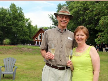 Colleagues Tom Wilson and Deb O'Grady enjoyed champagne by the Ottawa River waterfront at a charity tea party for Ryan's Well Foundation, held Sunday, July 20, 2014, in Plaisance, Que.