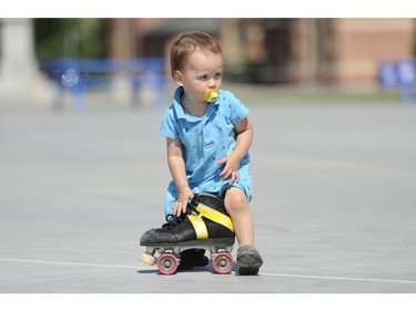 Connor Desmoulin, 18 months, plays with a roller skate after the Rideau Valley Roller Girls' Roller Derby Expo at the Rink of Dreams at Ottawa City Hall's Marion Dewar Plaza in Ottawa on Saturday, July 12, 2014.