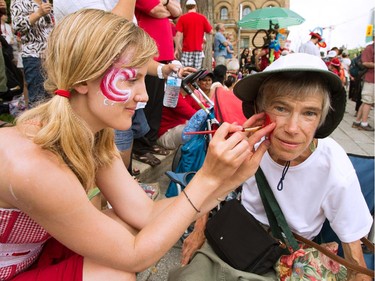 Constance Snelgrove gets into the spirit of the day by having a maple leaf painted on her cheek by Sitia Portielje as people flock to Parliament Hill and the downtown core to enjoy Canada's 147th birthday.