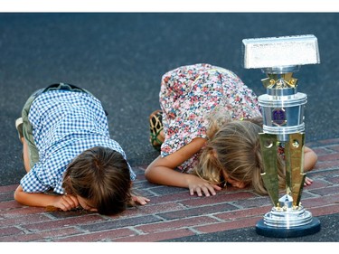 INDIANAPOLIS, IN - JULY 27:  (L-R) Leo Benjamin and Ella Sophia, children of Jeff Gordon, driver of the #24 Axalta Chevrolet, celebrate by kissing the bricks after their father's victory in the NASCAR Sprint Cup Series Crown Royal Presents The John Wayne Walding 400 at the Brickyard Indianapolis Motor Speedway on July 27, 2014 in Indianapolis, Indiana.