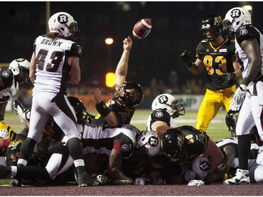 Hamilton Tiger-Cats quarterback Dan LeFevour, centre, lets go of the ball after scoring the game-winning touchdown late in the fourth quarter to defeat the Ottawa Redblacks in their CFL home opener in Hamilton, Ont., Saturday, July 26, 2014.