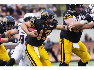 Hamilton Tiger-Cats quarterback Dan LeFevour, centre, runs the ball against the Ottawa RedBlacks during their CFL home opener in Hamilton, Ont., Saturday, July 26, 2014.