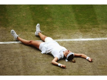LONDON, ENGLAND - JULY 05:  Petra Kvitova of Czech Republic falls to the floor as she celebrates championship point and winning the Ladies' Singles final match against Eugenie Bouchard of Canada on day twelve of the Wimbledon Lawn Tennis Championships at the All England Lawn Tennis and Croquet Club on July 5, 2014 in London, England.