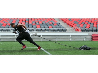 DL Monte Lewis pulls sandbags on the sidelines as the Ottawa Redblacks practice at TD Place Stadium at Lansdowne Park on Monday, July 14, 2014.