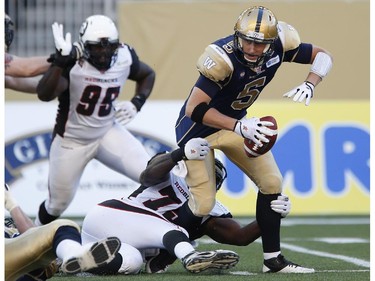 Winnipeg Blue Bombers' quarterback Drew Willy (5) gets sacked by Ottawa Redblacks' Jonathan Williams (75) during the first half of CFL action in Winnipeg Thursday, July 3, 2014.